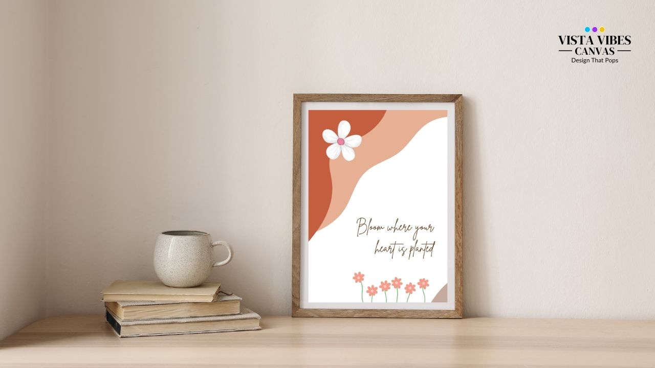 Framed artwork with Floral boho wall art printable with quote “Bloom Where Your Heart Is Planted” –  on a wall above books and a mug. It's a digital download with blooming flowers for inspiring home decor